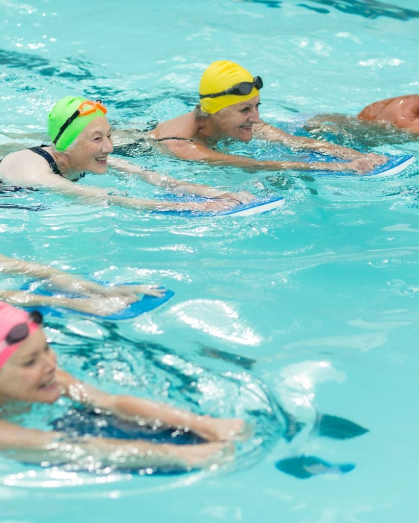 Swimmers with kickboards swimming in pool