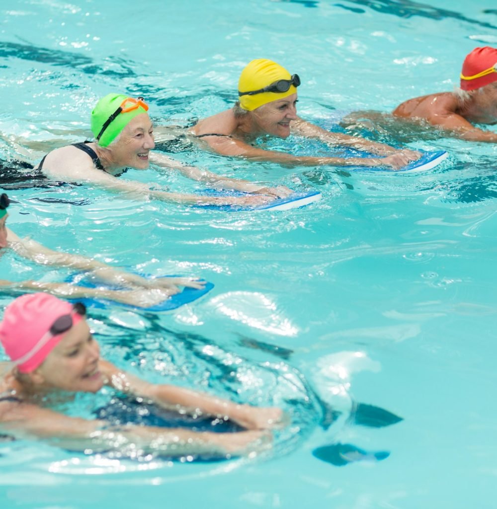 Swimmers with kickboards swimming in pool