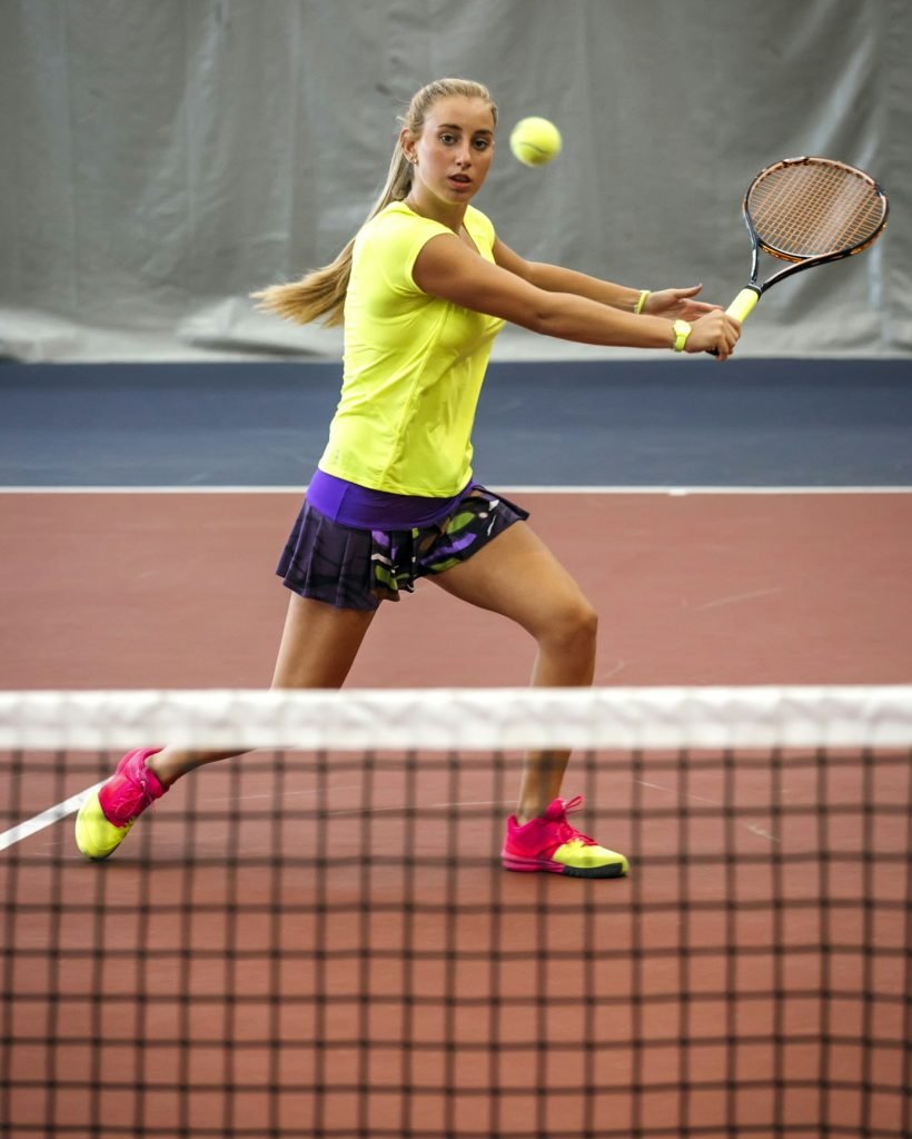 Young woman playing tennis in an indoor tennis center